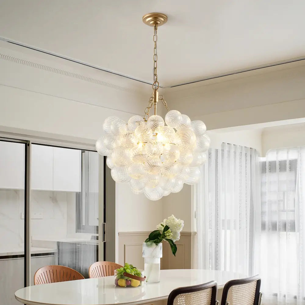 Decorbites gold pendant chandelier with adjustable height features a modern glass design and gold-toned metal frame