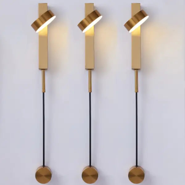 Three modern gold-toned decorbites™ wall lamps with twisted cylindrical shades and dimmer switch black cords