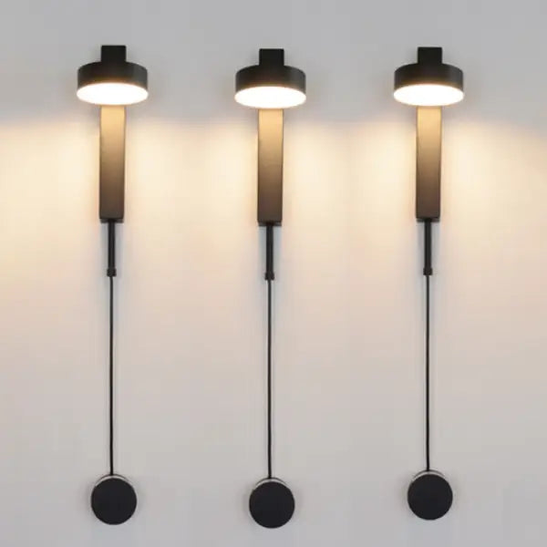 Three sleek black DecorBites™ wall lamps with cylindrical shades and dimmer switch for adjustable lighting