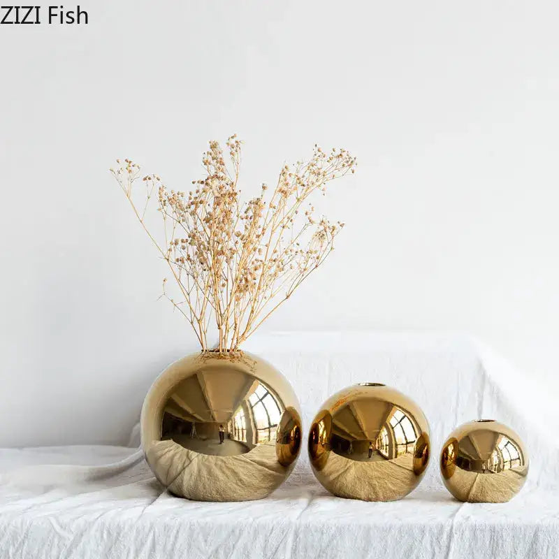 Set of three golden ball ceramic vases with reflective surfaces in descending size for elegant home decor by decorbites