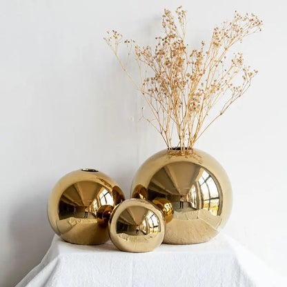 Decorbites golden ball ceramic vases in reflective gold finish arranged in varying sizes for elegant home decor