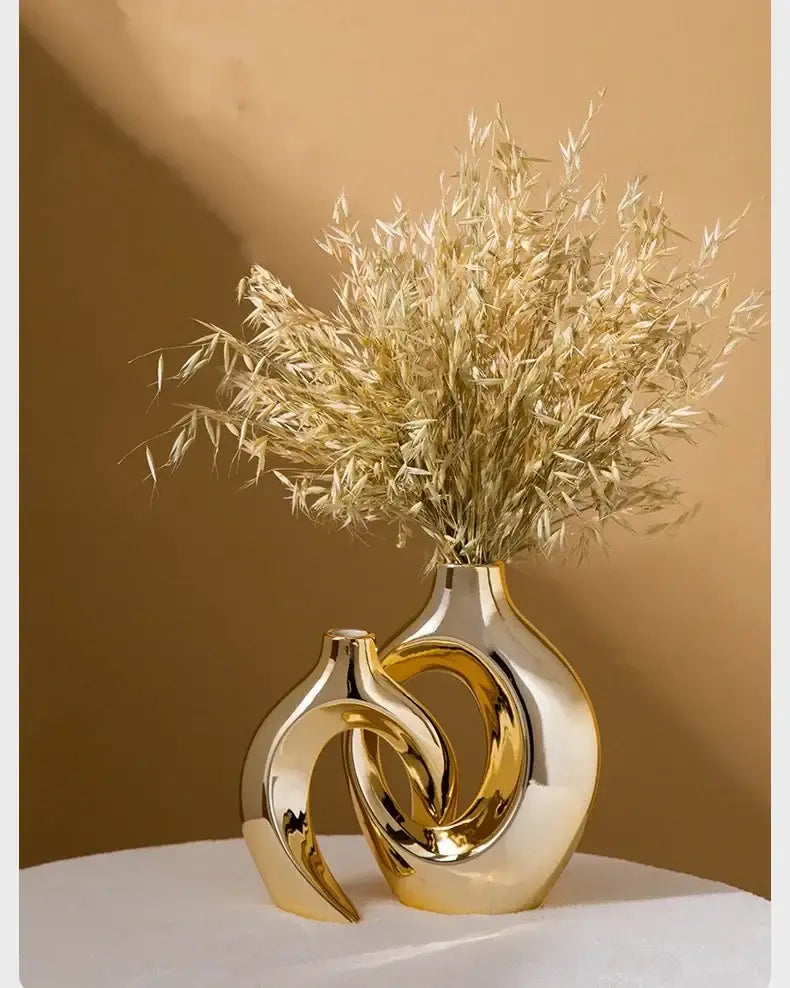 DecorBites™ golden flower vase with intertwined ceramic design holding dried golden grass for home decor accessory