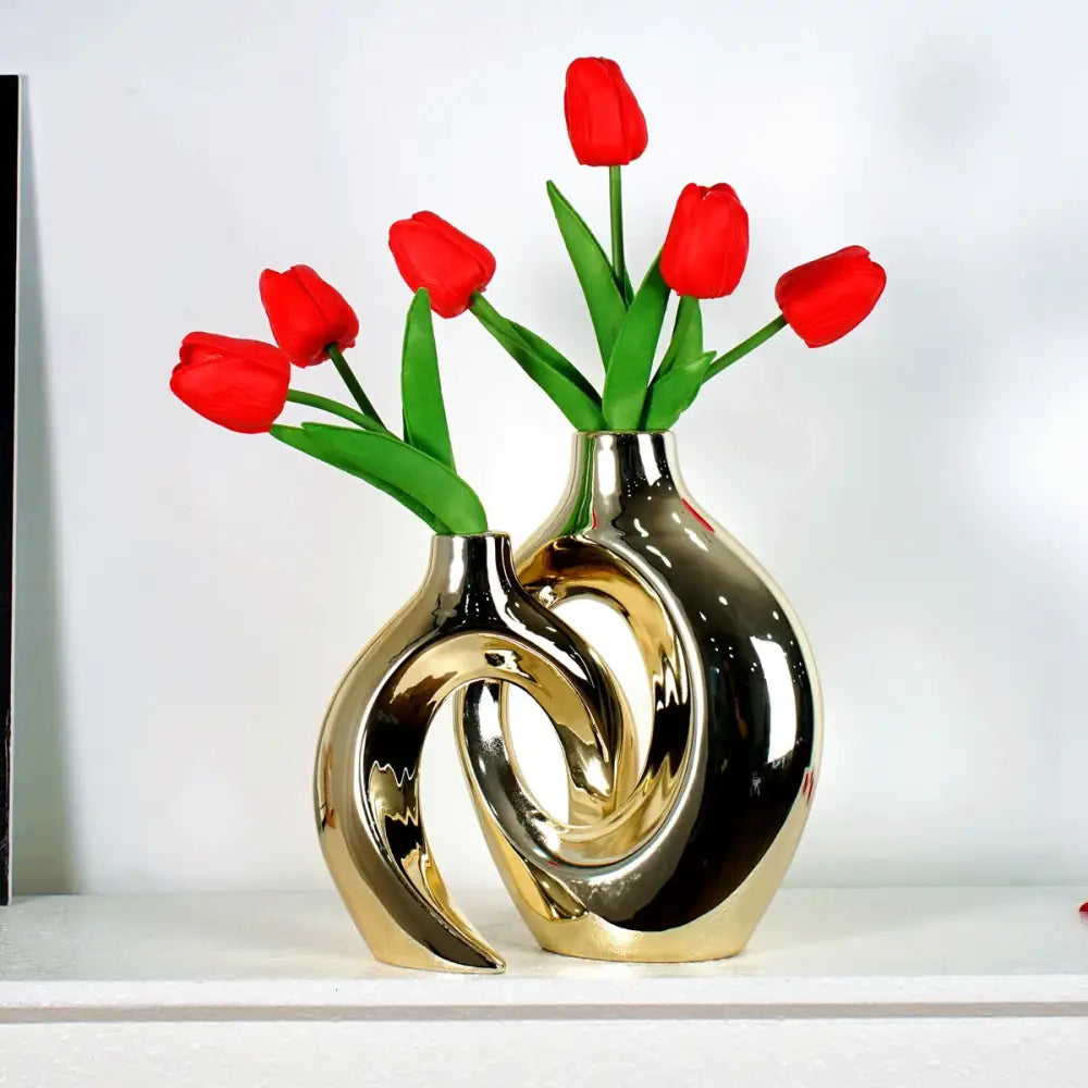 Shiny golden flower vase with sculptural ceramic design holding vibrant red tulips for home decor accessory