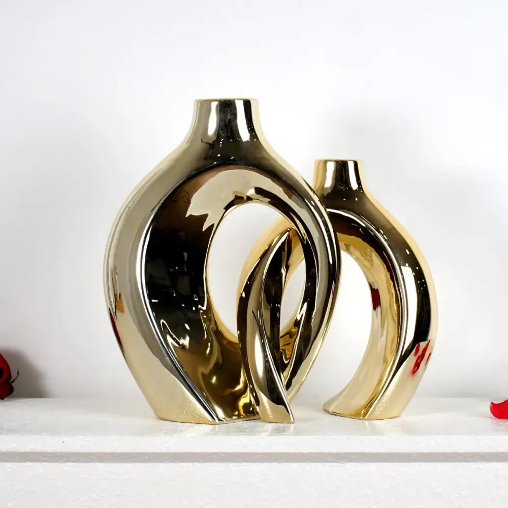 Two gold-toned ceramic golden flower vases with glossy finishes and abstract flowing curves by DecorBites™