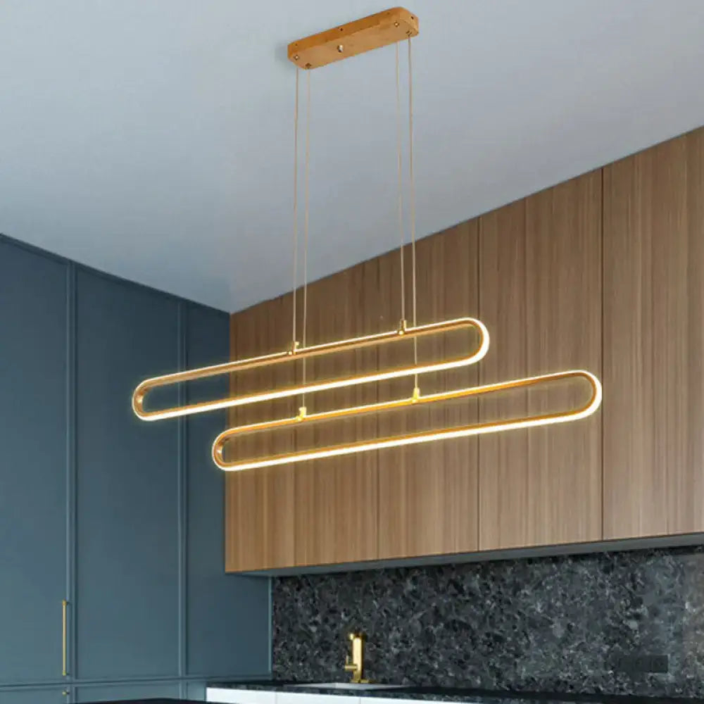 Modern gold-toned decorbites™ led aluminum island pendant light with warm white elliptical loops and wooden ceiling mount with fixture width options 39’’/47’’ compatible with 220v-240v 110v-120v