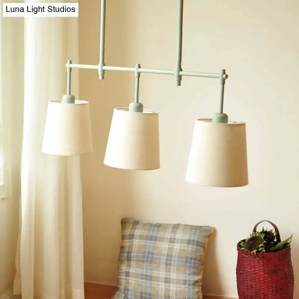 DecorBites green barrel fabric pendant light with three off-white shades on sage green frame ceiling light fixture