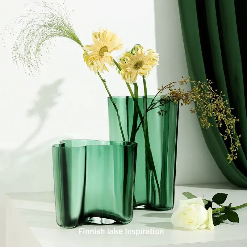 Two translucent emerald green glass vases with wavy organic contours from DecorBites green glass vase collection