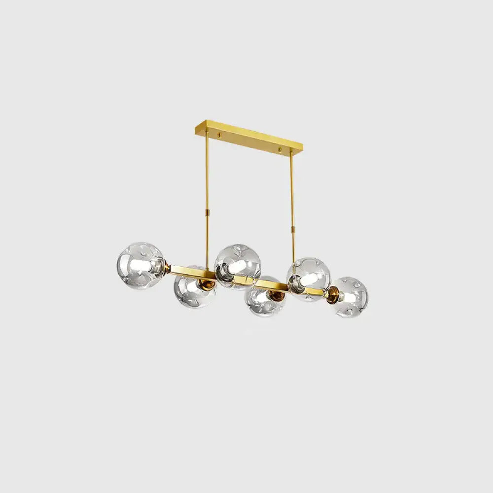 Decorbites modern brass-finished chandelier with five hand-blown dimpled glass globe bulbs in linear design for restaurant
