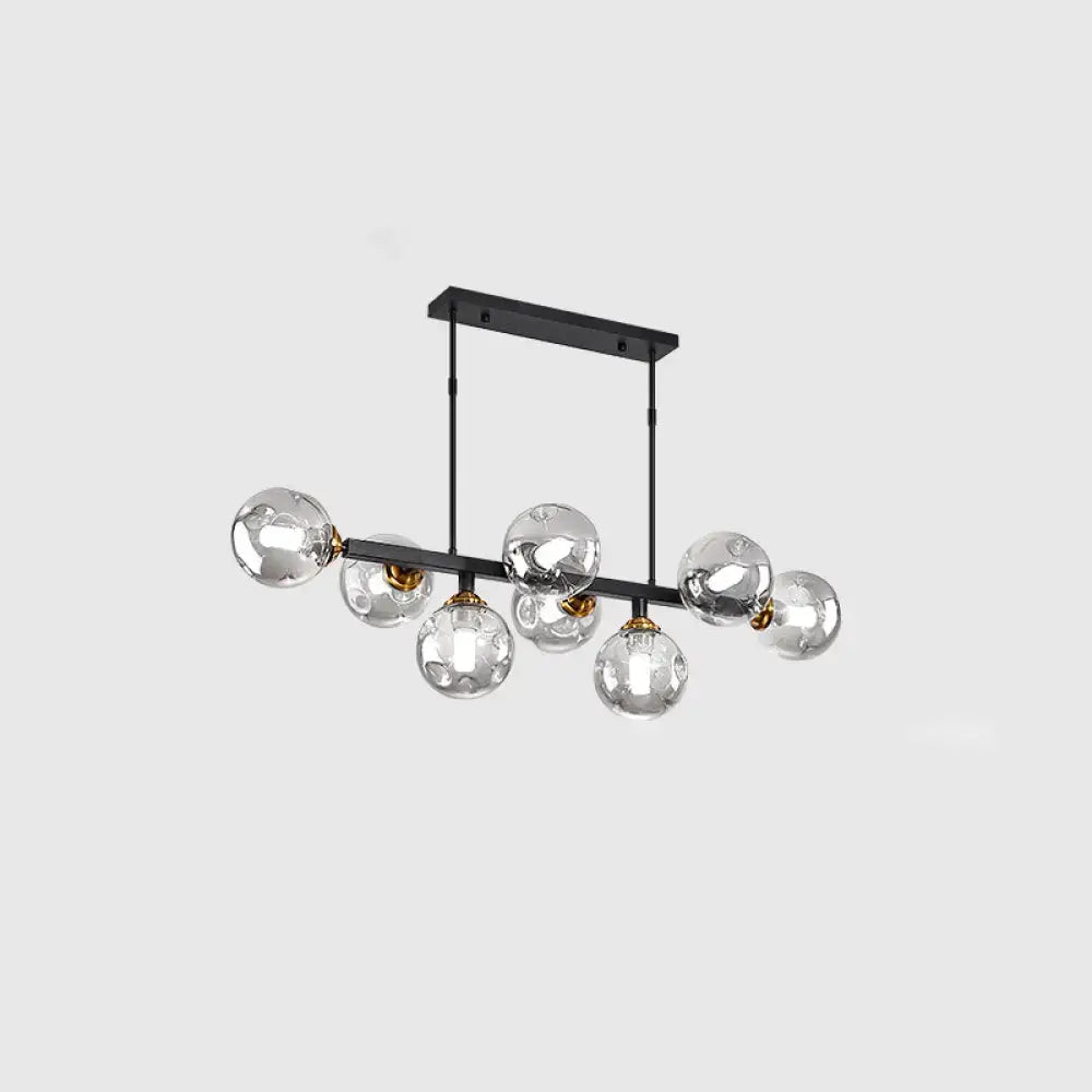 Modern black metal chandelier with seven hand-blown dimpled glass globe bulbs and gold-toned accents for restaurants