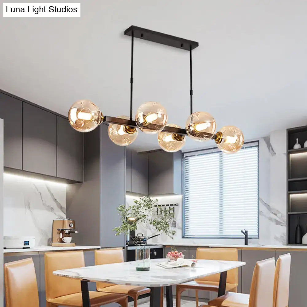 Modern black metal chandelier with five amber hand-blown dimpled glass globe bulbs for restaurant lighting