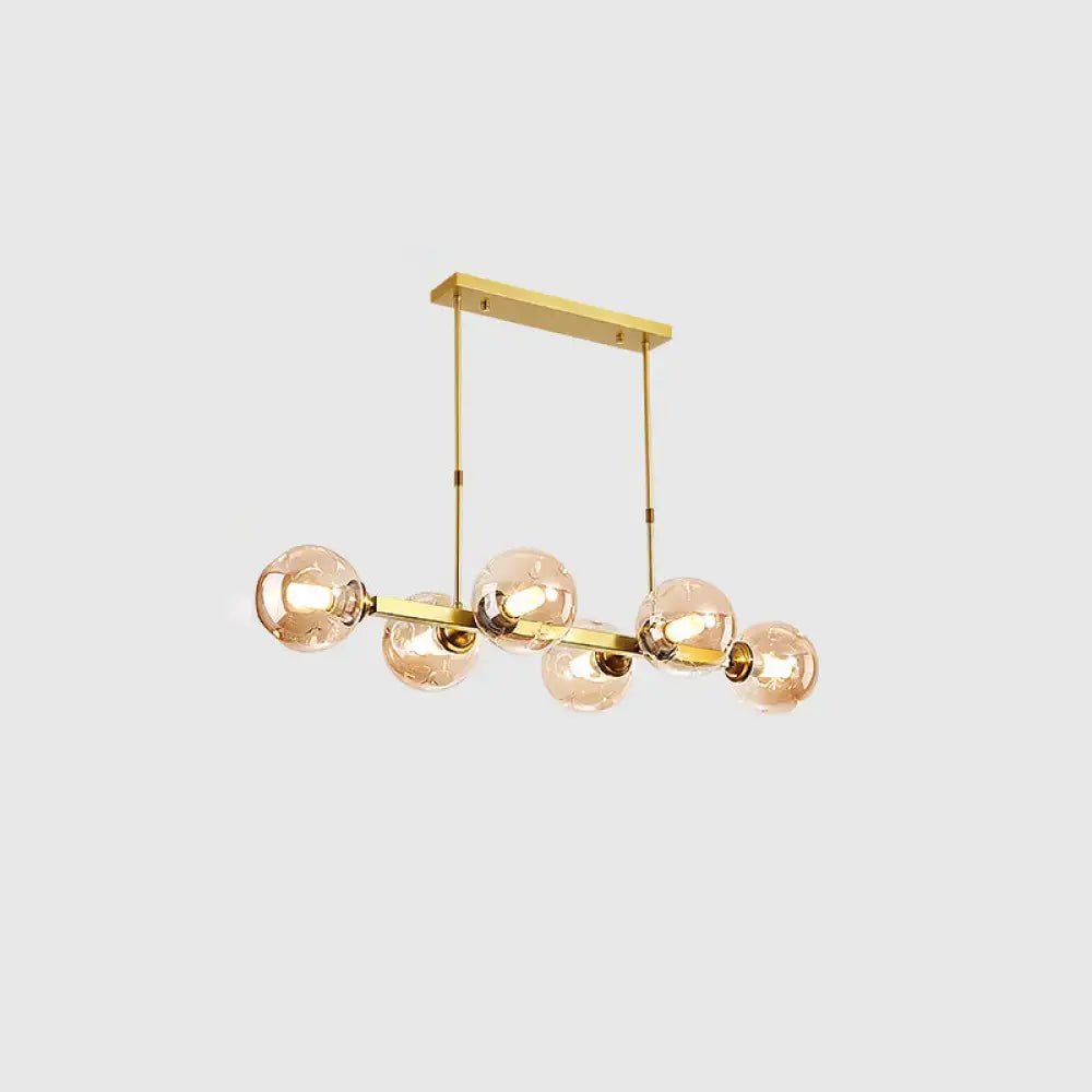 Gold-toned DecorBites™ modern island pendant lamp with five hand-blown dimpled glass amber bulbs for restaurant use