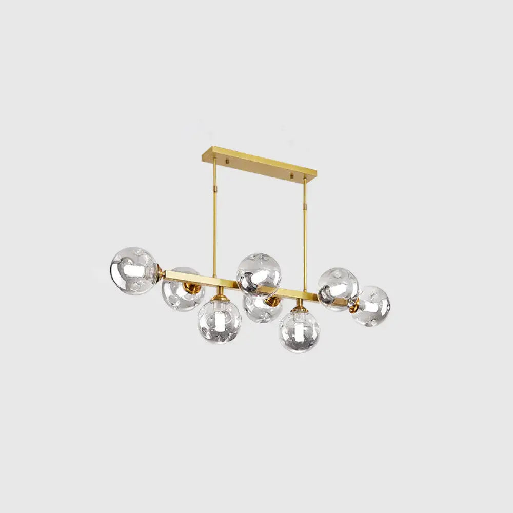 Modern gold-toned decorbites™ island pendant lamp with hand-blown dimpled glass globe bulbs for restaurant lighting