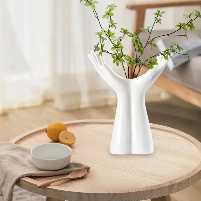 White ceramic hand shaped porcelain flower vase holding green branches for elegant home decor display