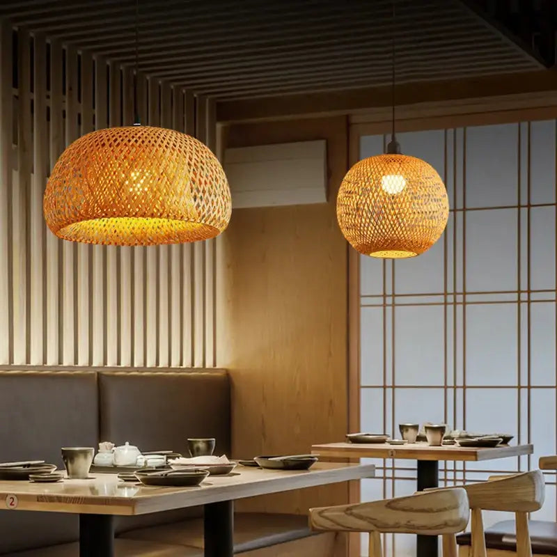 Warm golden-hued pendant light chandelier featuring hand-woven bamboo spheres by DecorBites™ hanging from ceiling