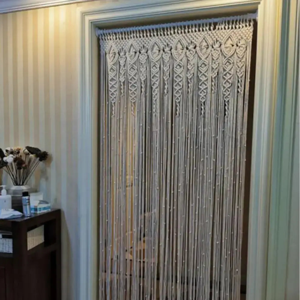 Cream-colored DecorBites™ hand-woven macrame door curtain with intricate geometric patterns and hanging tassels