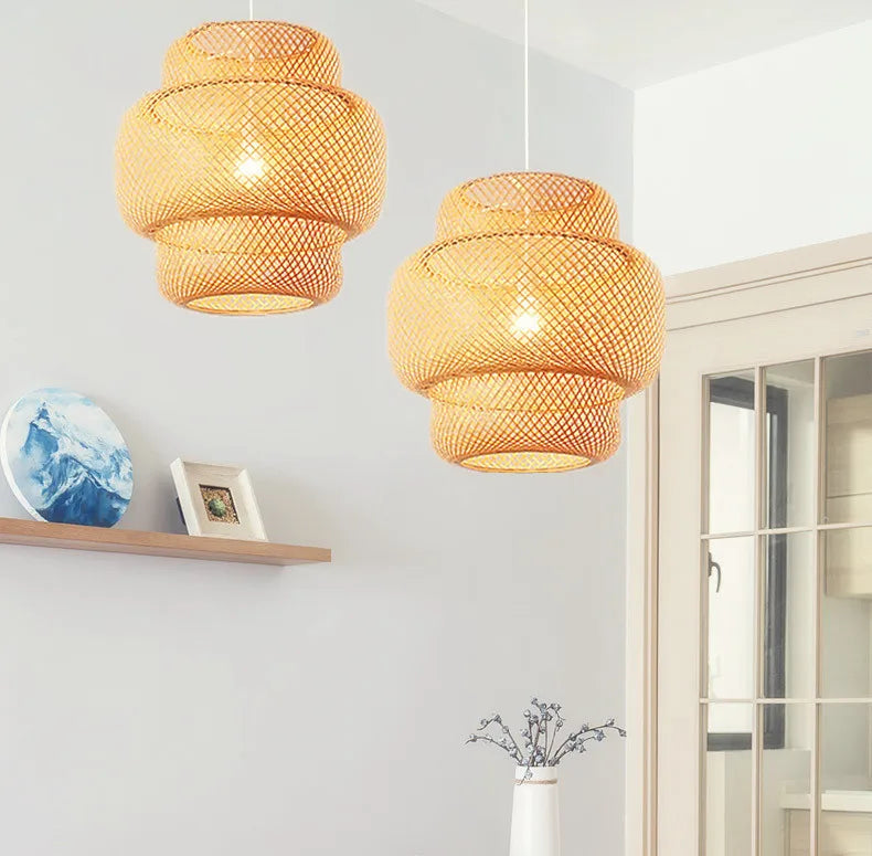 Two warm-toned handcrafted DecorBites™ bamboo pendant lamps with woven natural rattan tiered shades hang from ceiling