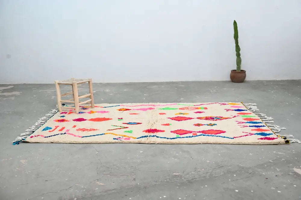 DecorBites™ handcrafted moroccan azilal rug in cream with vibrant geometric patterns and colorful fringe 246 x 146 cm