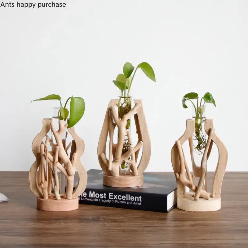 Three rustic handcrafted wooden vases with natural light wood finish and green plants for creative home decor
