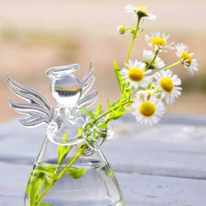 Clear glass angel-shaped handmade vase by DecorBites holding white daisies with yellow centers for home decor