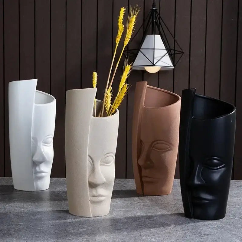 Four handmade ceramic face vases with stylized human faces and split-open design for unique home decor art vase sculpture