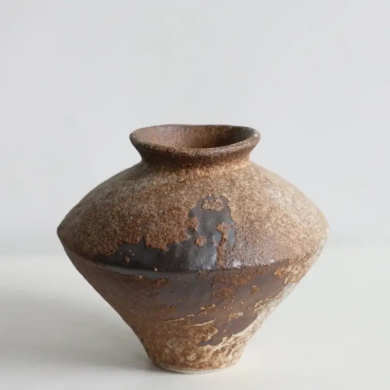 Rustic brown handmade ceramic vase with textured earthy surface and dark glaze patches for zen flower arrangements