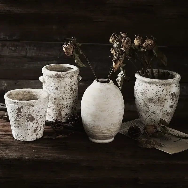 A collection of rustic speckled white handmade ceramic vases with a distressed finish for vintage home decor