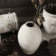 A rustic white handmade ceramic vase with a speckled weathered finish and oval shape from decorbites vintage style