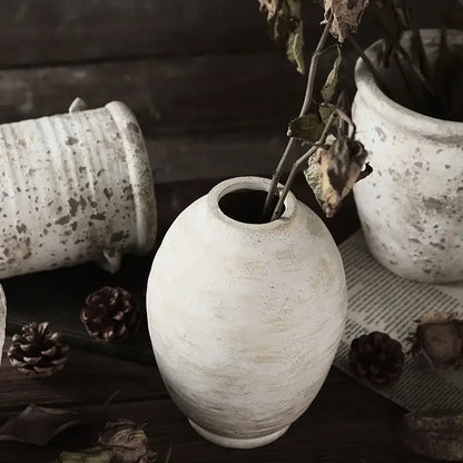 A rustic white handmade ceramic vase with a speckled weathered finish and oval shape from decorbites vintage style