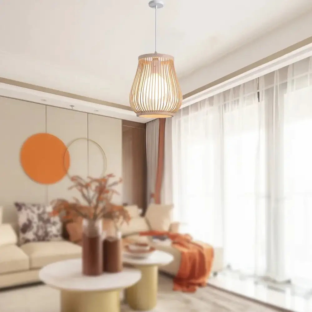 A warm-toned cylindrical bamboo rattan wicker pendant light with vertical slats hanging from a metal rod by decorbites™