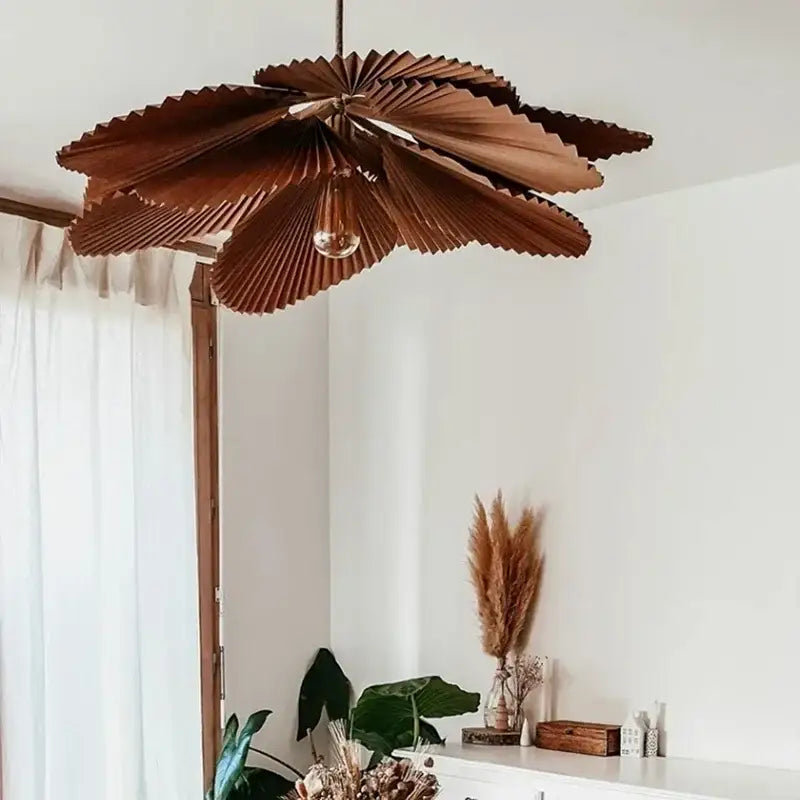 A warm-toned brown wooden pendant light with layered petals hanging from a black cord decorbites handmade floral chandelier