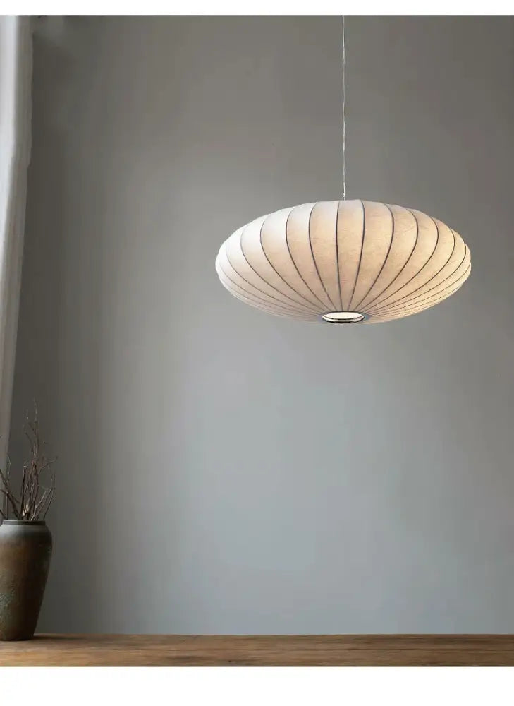 Cream-colored ribbed paper pendant light with metallic suspension cord in a DecorBites™ handmade japanese style silk chandelier