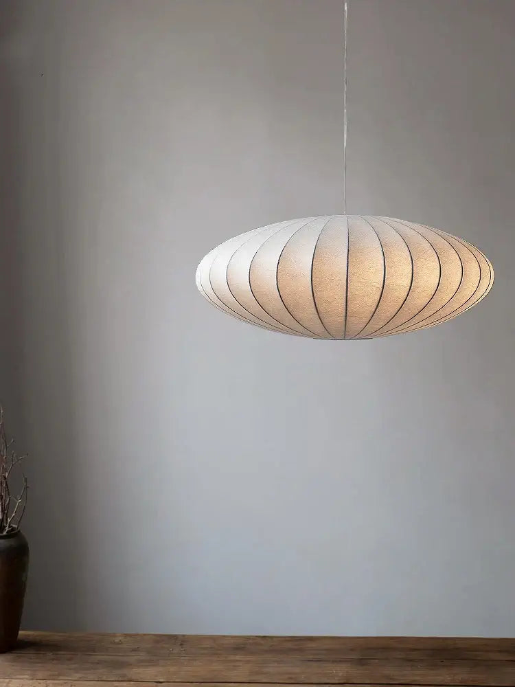 A modern oval-shaped decorbites™ handmade japanese style silk chandelier with warm beige segmented panels suspended by cord