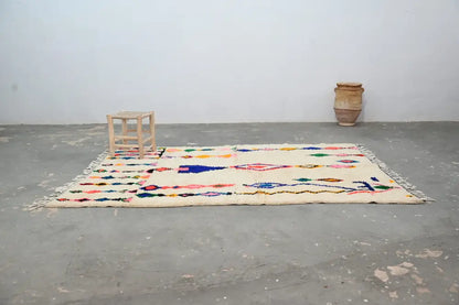 Cream-colored DecorBites™ handmade moroccan azilal carpet 240x160 cm with vibrant geometric patterns and fringed edges