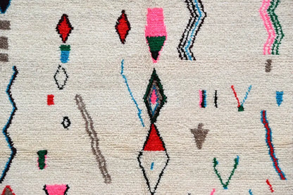 Beige moroccan handmade azilal rug in natural wool with vibrant geometric patterns in red pink green blue and black 223x157cm