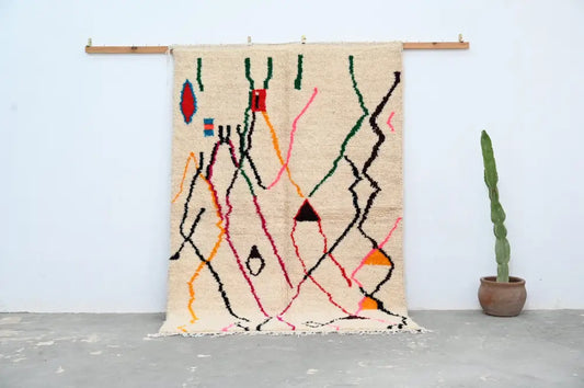 Beige moroccan handmade azilal rug with abstract geometric patterns in red green black orange and pink by DecorBites