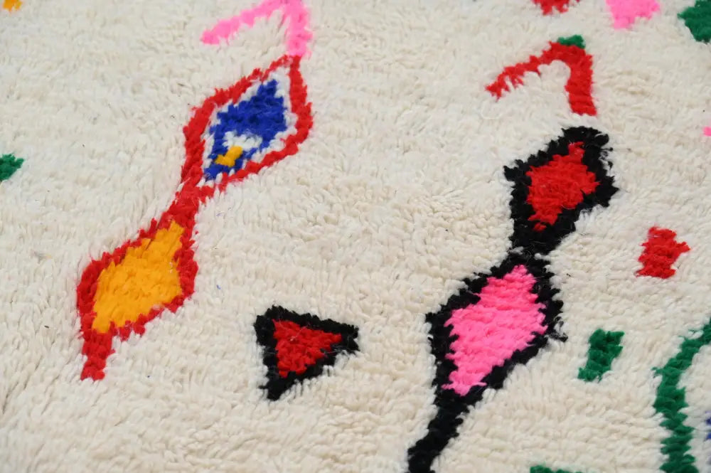 DecorBites™ handmade moroccan azilal rug in natural wool with vibrant geometric patterns in bold reds blues and greens