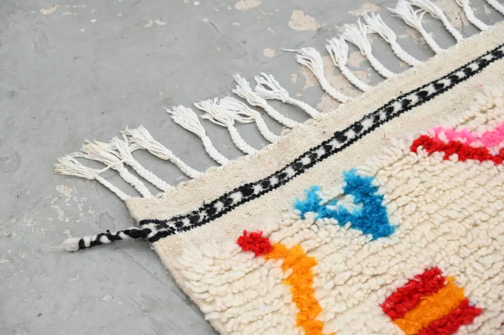 Decorbites™ handmade moroccan azilal rug in natural wool with cream base and bold geometric patterns with white tassels