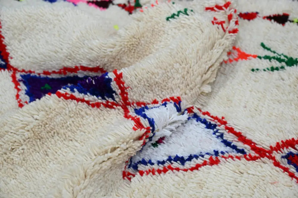 Decorbites™ handmade cream-colored moroccan azilal rug with plush texture and bold geometric red blue green patterns 231x152 cm