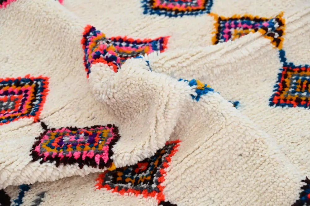 Cream-colored handmade moroccan azilal rug with vibrant pink blue orange and black geometric patterns 236x155cm