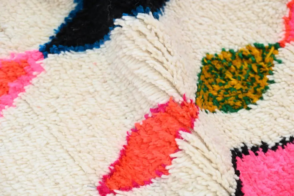 Vibrant handmade moroccan azilal rug with bold geometric patterns in cream pink orange green and black wool 237x155 cm