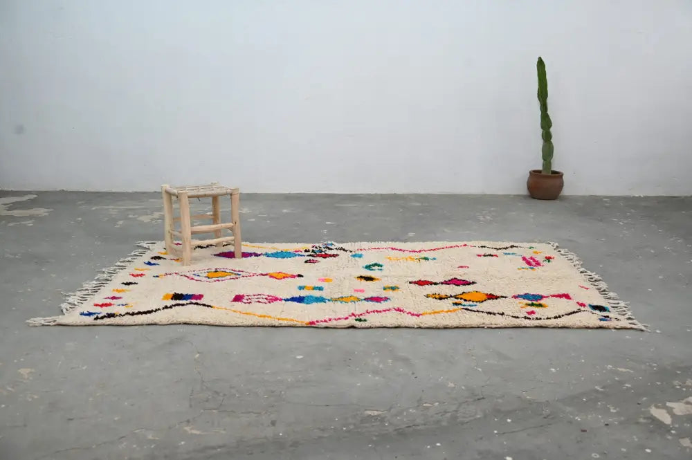 Beige moroccan-style azilal rug 240x132cm with colorful geometric patterns and fringed edges by decorbites
