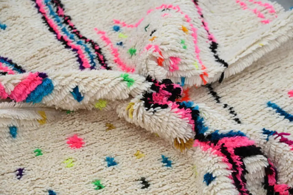 DecorBites™ handmade traditional azilal rug cream with textured vibrant pink blue and black geometric patterns and speckles