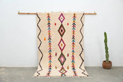 Beige handmade moroccan azilal rug with colorful geometric patterns and fringed edges by DecorBites™ 242x150cm