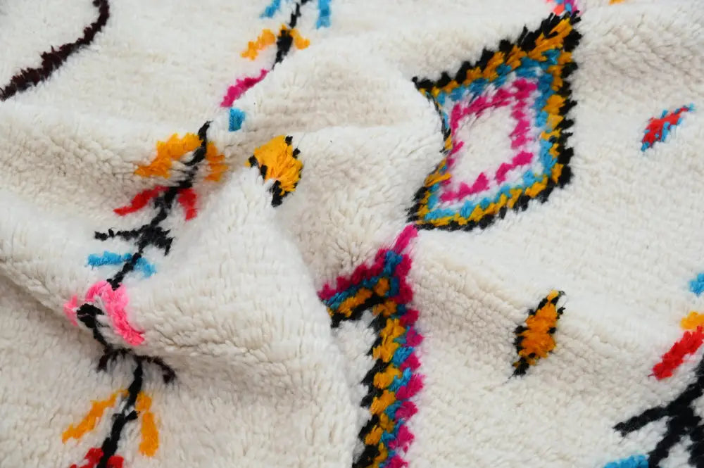 Cream-colored plush handmade moroccan azilal rug with vibrant black pink blue and orange geometric patterns 242x150cm