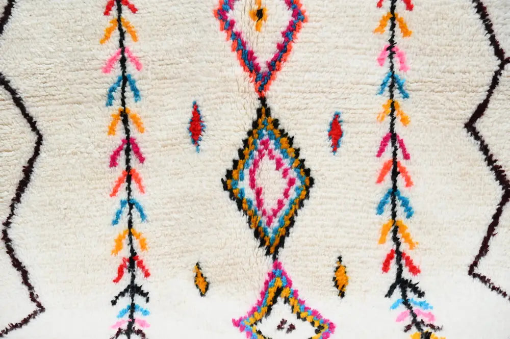 DecorBites™ handmade Moroccan Azilal rug with vibrant geometric pattern on cream base in pink blue orange and black