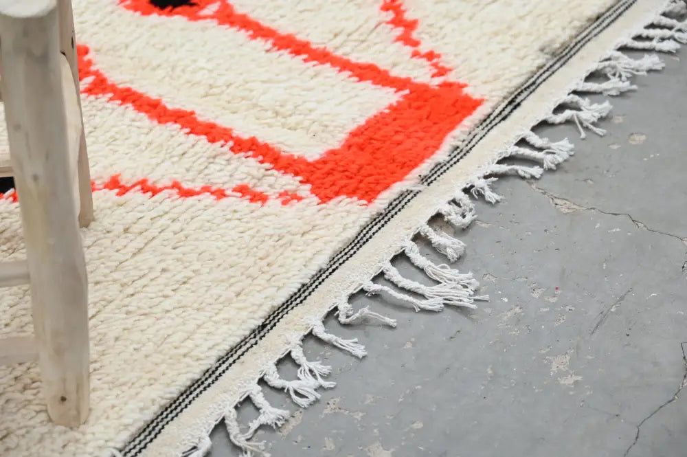Cream-colored handmade moroccan azilal rug with bold orange geometric patterns and fringed edges 245x141cm decorbites
