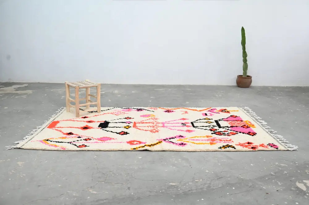 Decorbites™ handmade moroccan azilal rug featuring vibrant cream color with bold pink black and orange geometric patterns