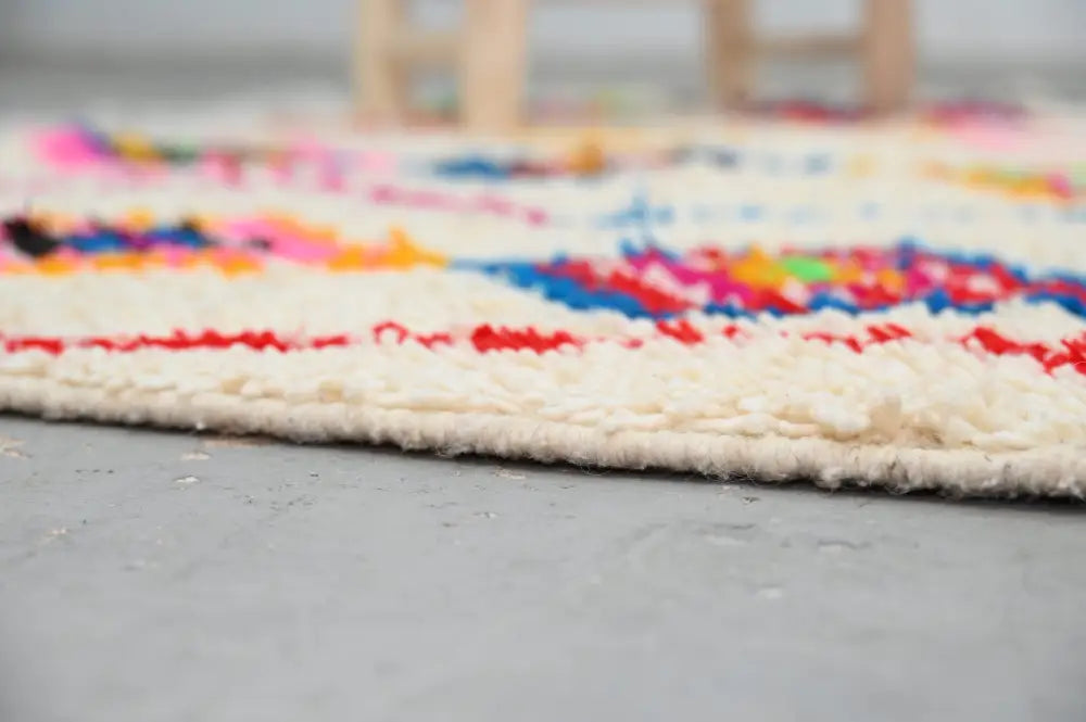 Colorful textured DecorBites™ handmade Moroccan azilal rug with cream border and vibrant geometric patterns