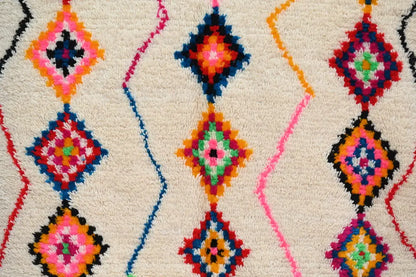 DecorBites™ handmade Moroccan azilal rug with fluffy cream base and vibrant multicolored traditional azilal diamond motifs
