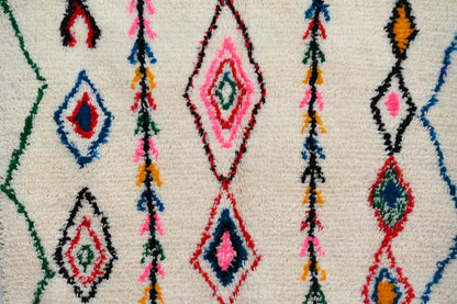 Vibrant moroccan handmade azilal rug with diamond and stripe patterns in pink blue red green yellow on natural wool cream base